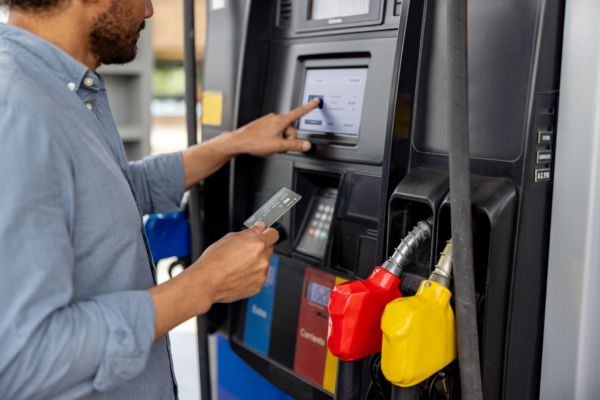 A fleet driver paying for gas at a station with a fuel card.