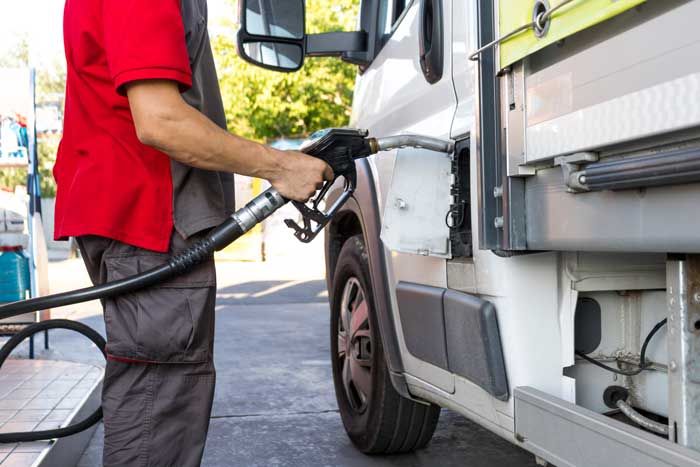 A fleet driver fuels his vehicle during a stop on his route using his fuel card.