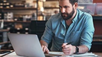 Small business owner reviewing fleet card reports on laptop