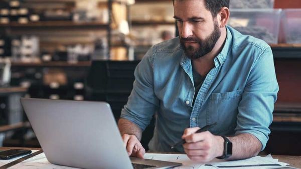 Small business owner reviewing fleet card reports on laptop