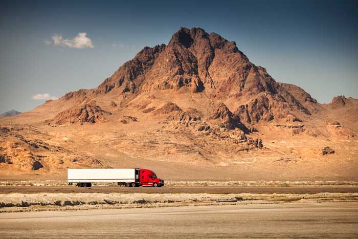 A semi truck trailer in a fleet on the route in the desert in the US.