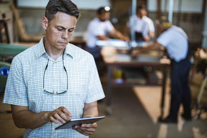 A small business owner reviews fleet card transactions in real-time from his tablet.