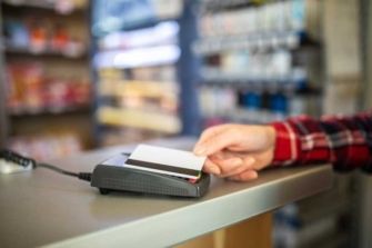 A trucker uses a fleet card to make purchases at a truck stop convenience store.