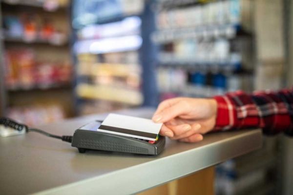 A trucker uses a fleet card to make purchases at a truck stop convenience store.